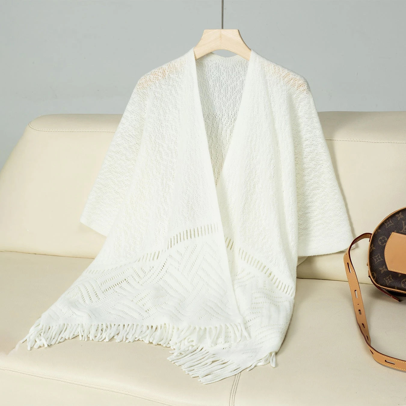 Ladies elegant knitted poncho with fringed details and striking pattern