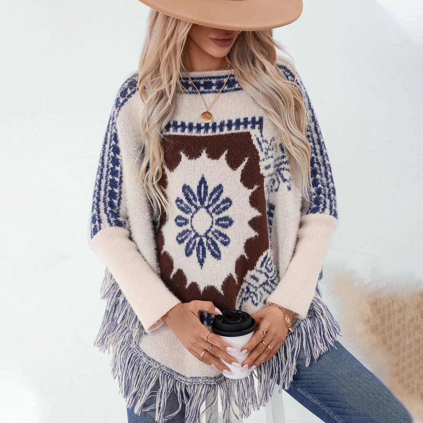 Ladies elegant knitted poncho with artistic pattern and fringed hem
