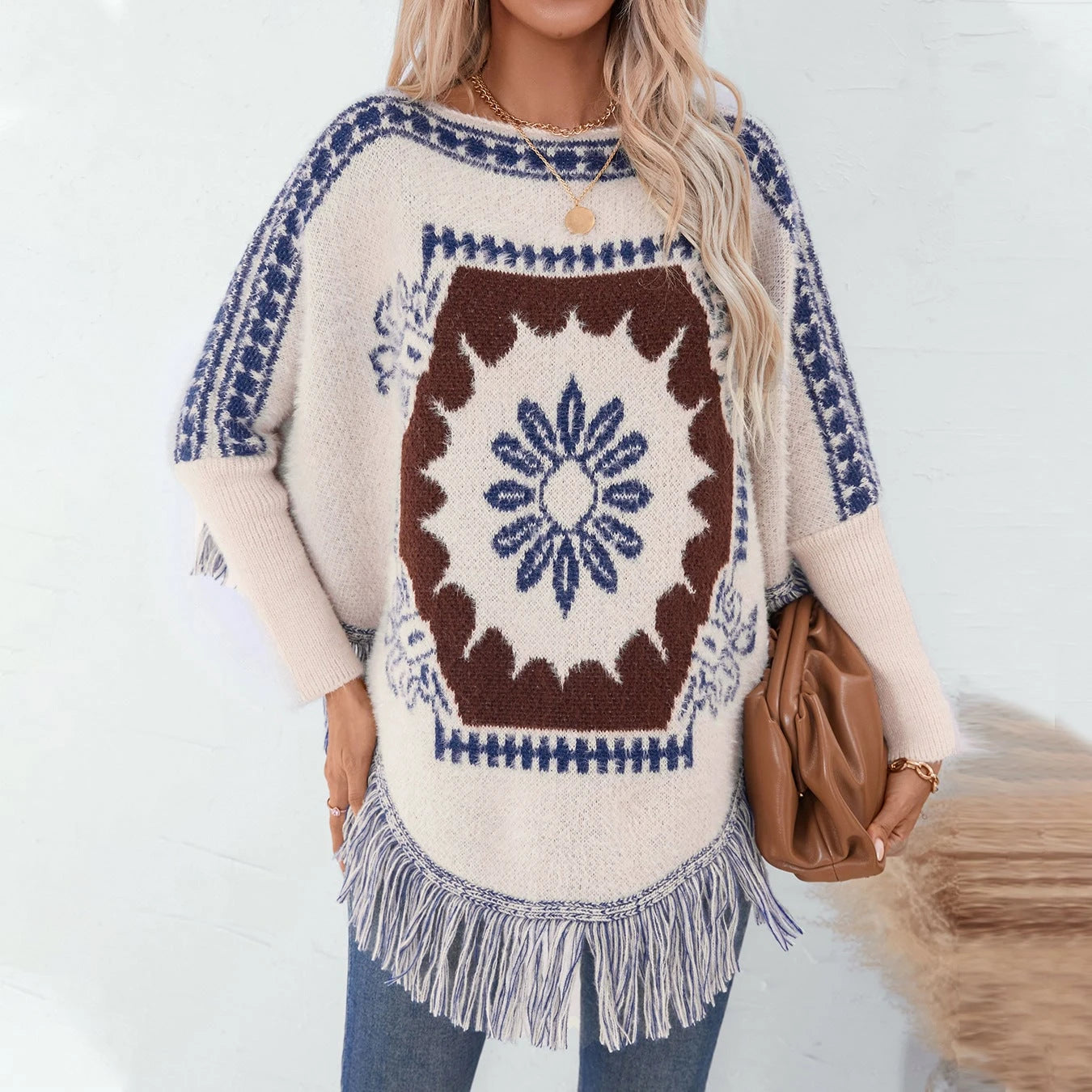 Ladies elegant knitted poncho with artistic pattern and fringed hem