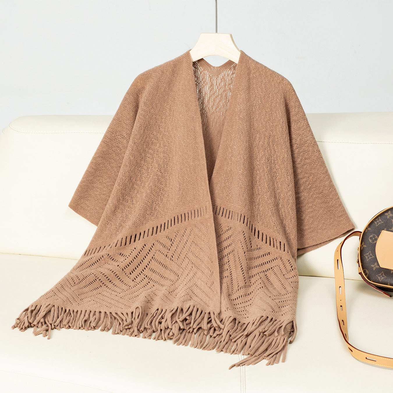 Ladies elegant knitted poncho with fringed details and striking pattern