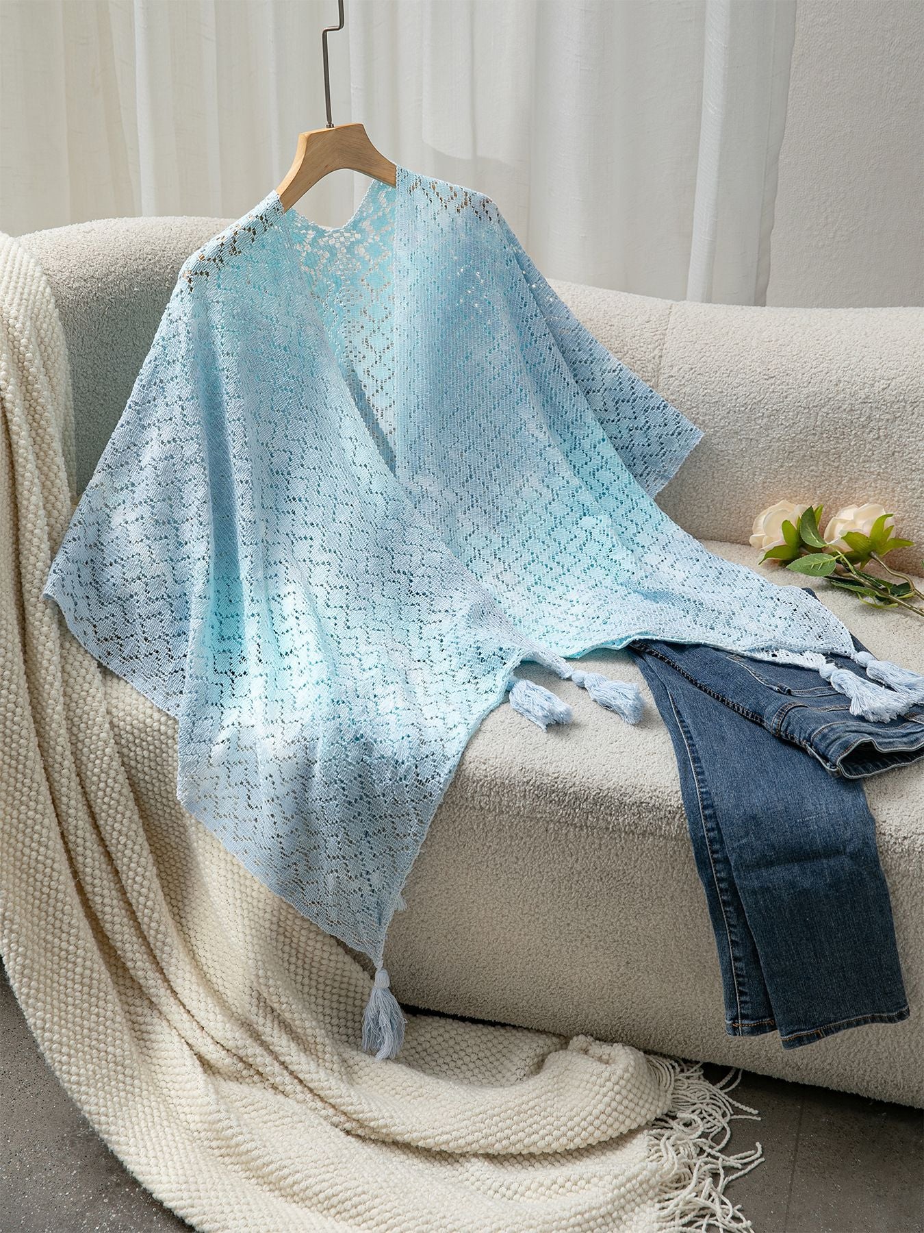 Ladies airy knitted poncho with decorative tassels