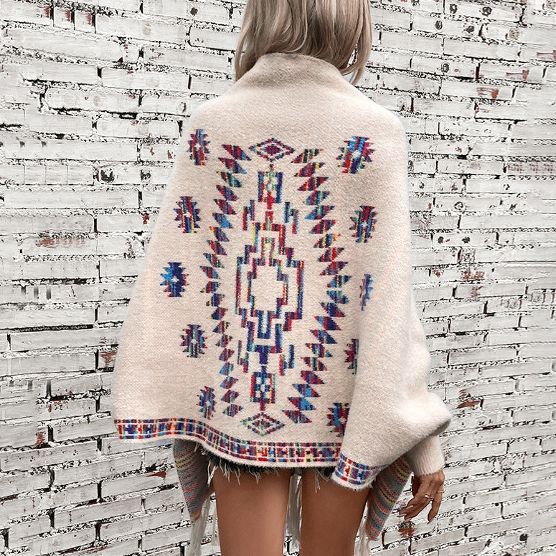 Women’s knitted poncho with colorful Navajo pattern and fringed hem