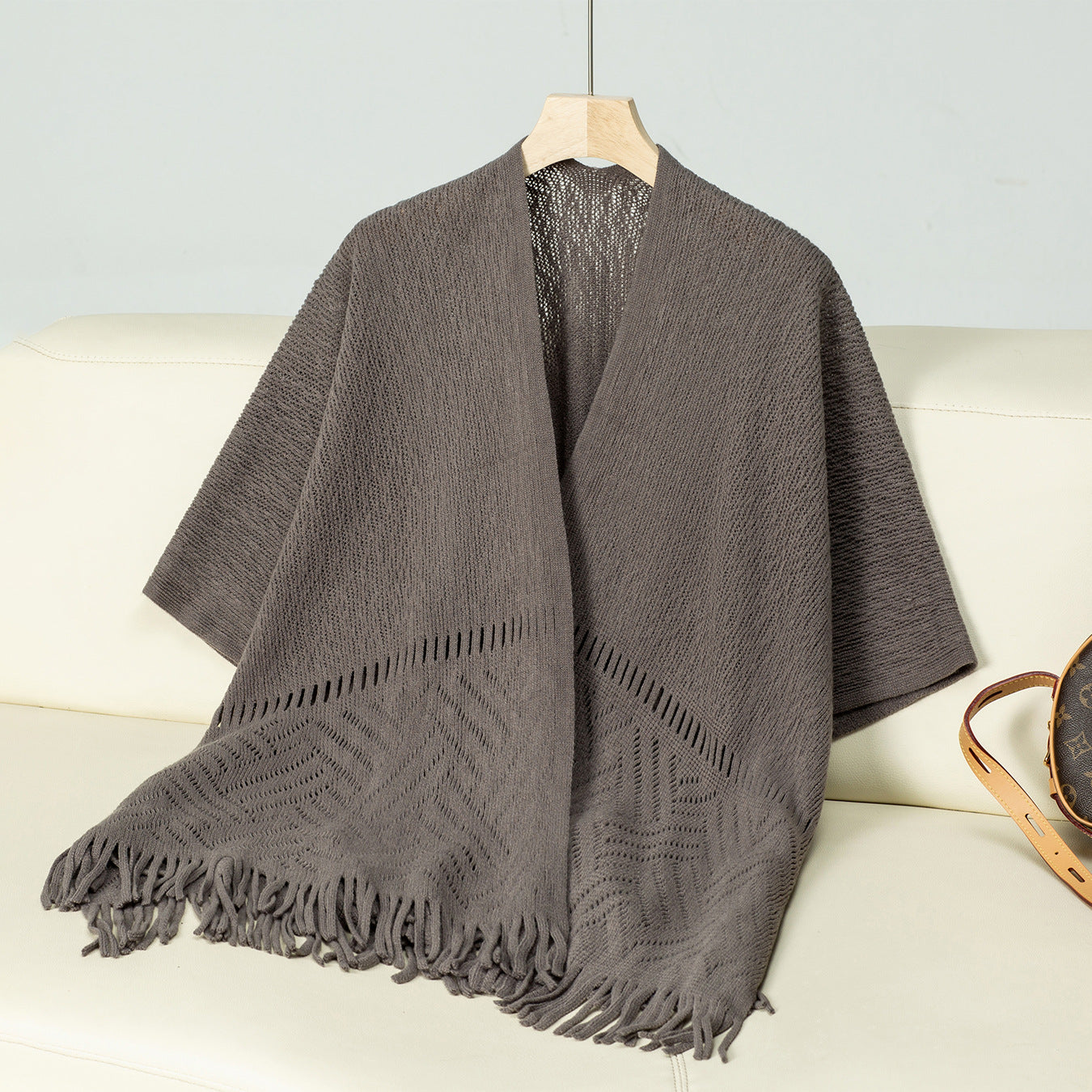 Ladies elegant knitted poncho with fringed details and striking pattern
