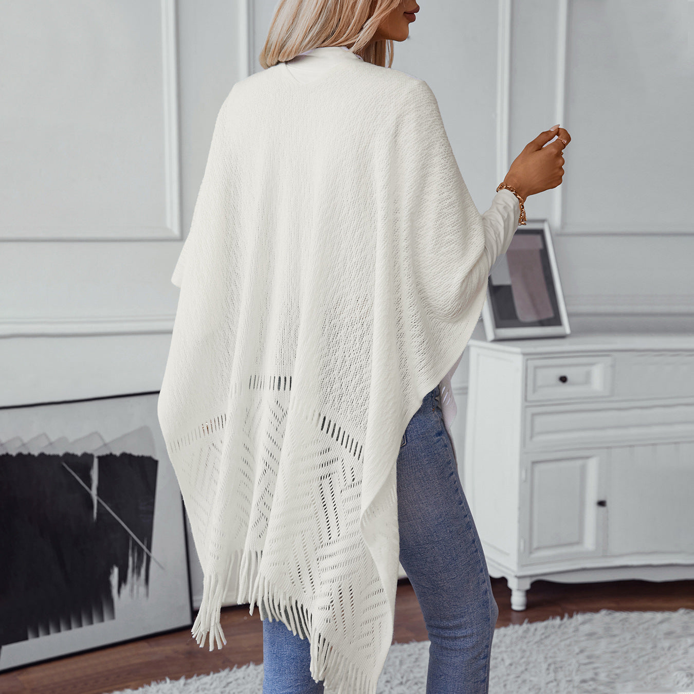 Ladies elegant knitted poncho with fringed details and striking pattern