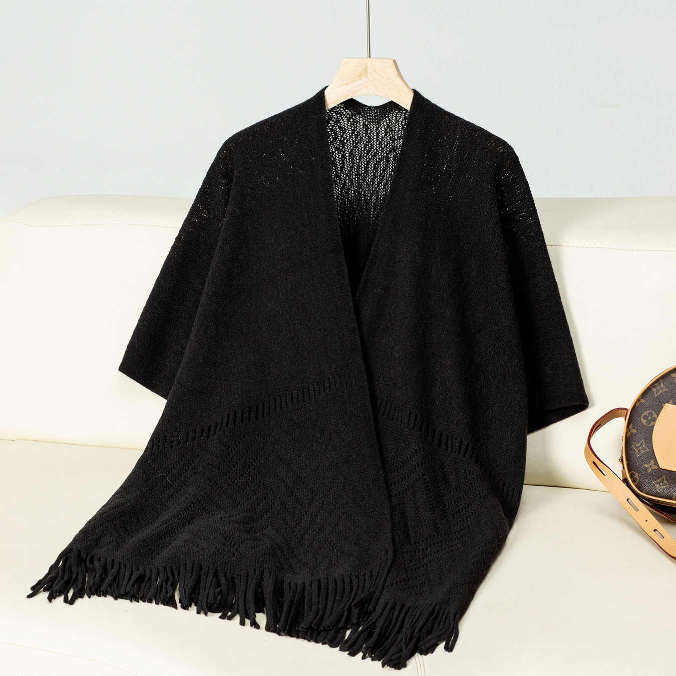 Ladies elegant knitted poncho with fringed details and striking pattern