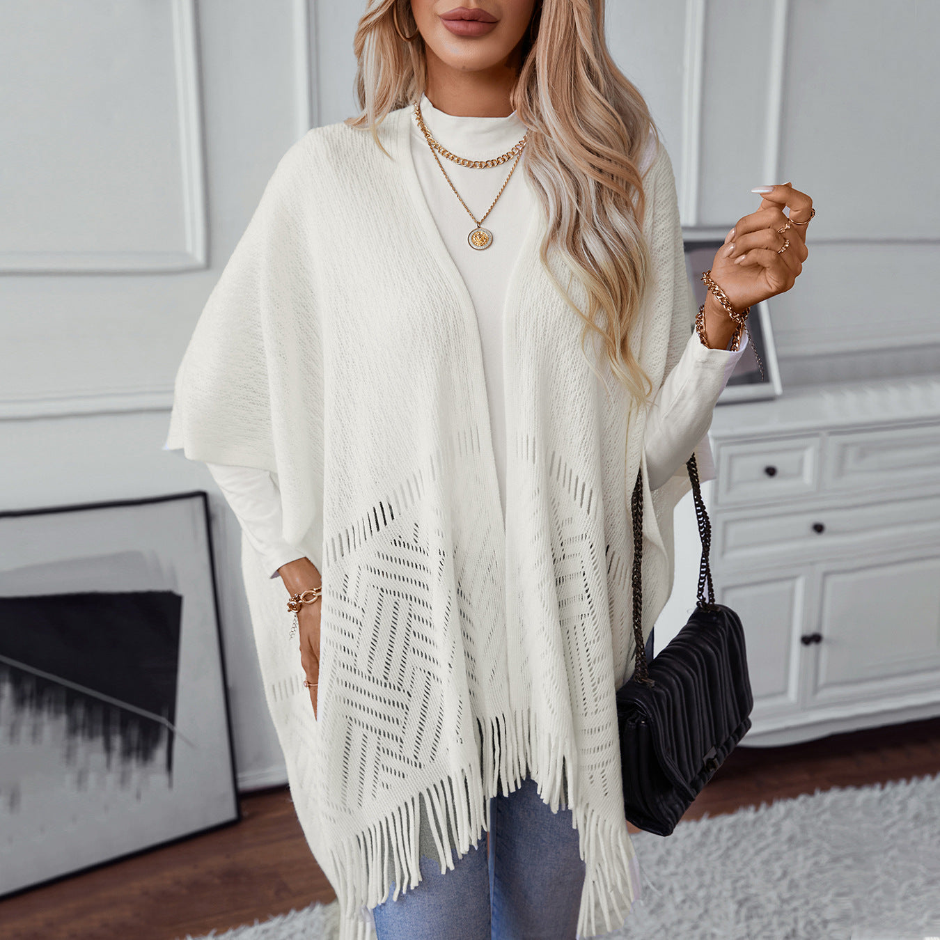 Ladies elegant knitted poncho with fringed details and striking pattern