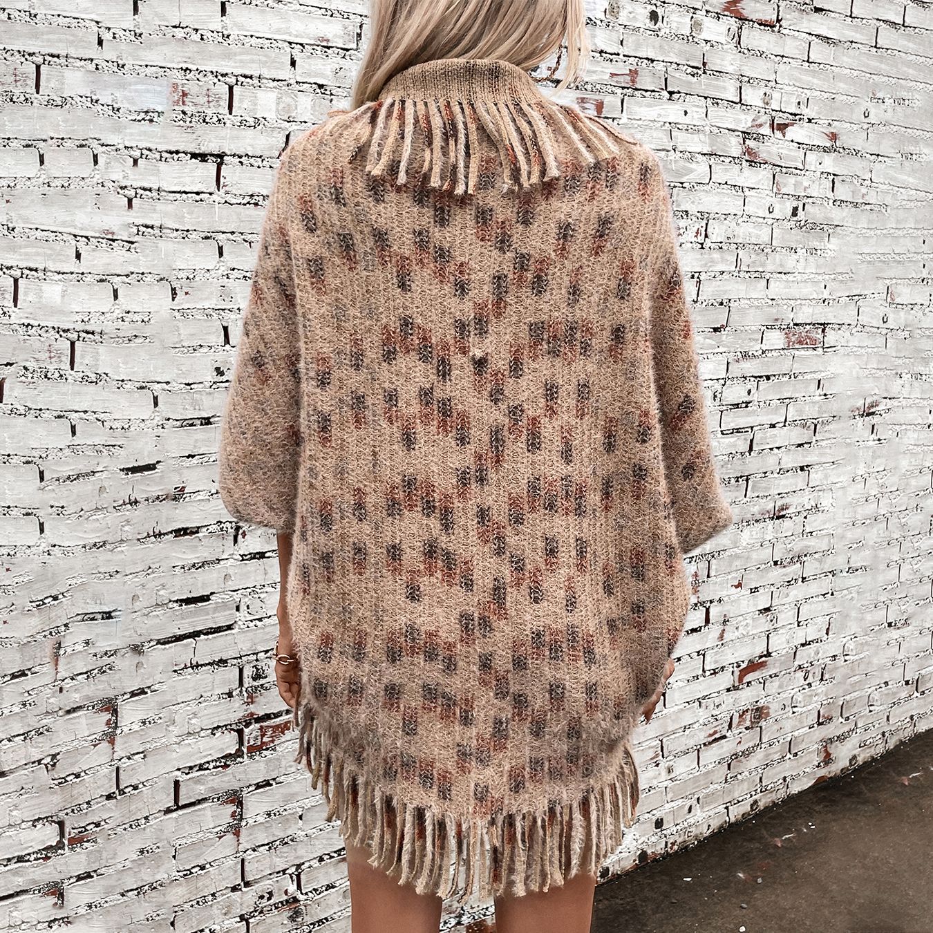 Women's elegant poncho with fringed details and modern check pattern