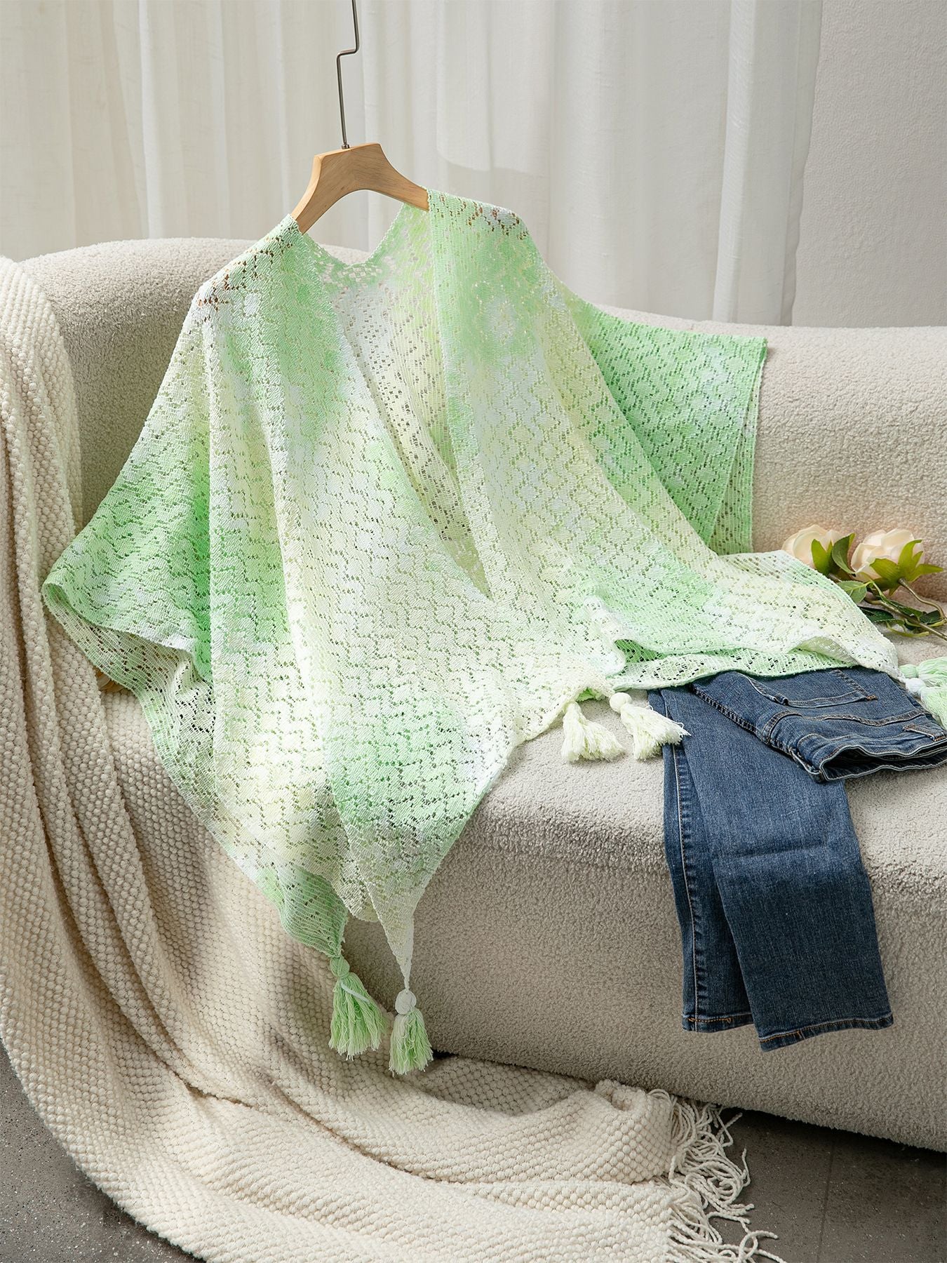 Ladies airy knitted poncho with decorative tassels