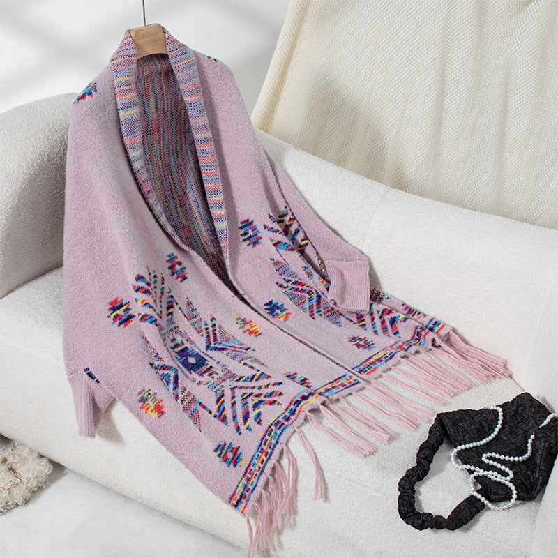 Women’s knitted poncho with colorful Navajo pattern and fringed hem