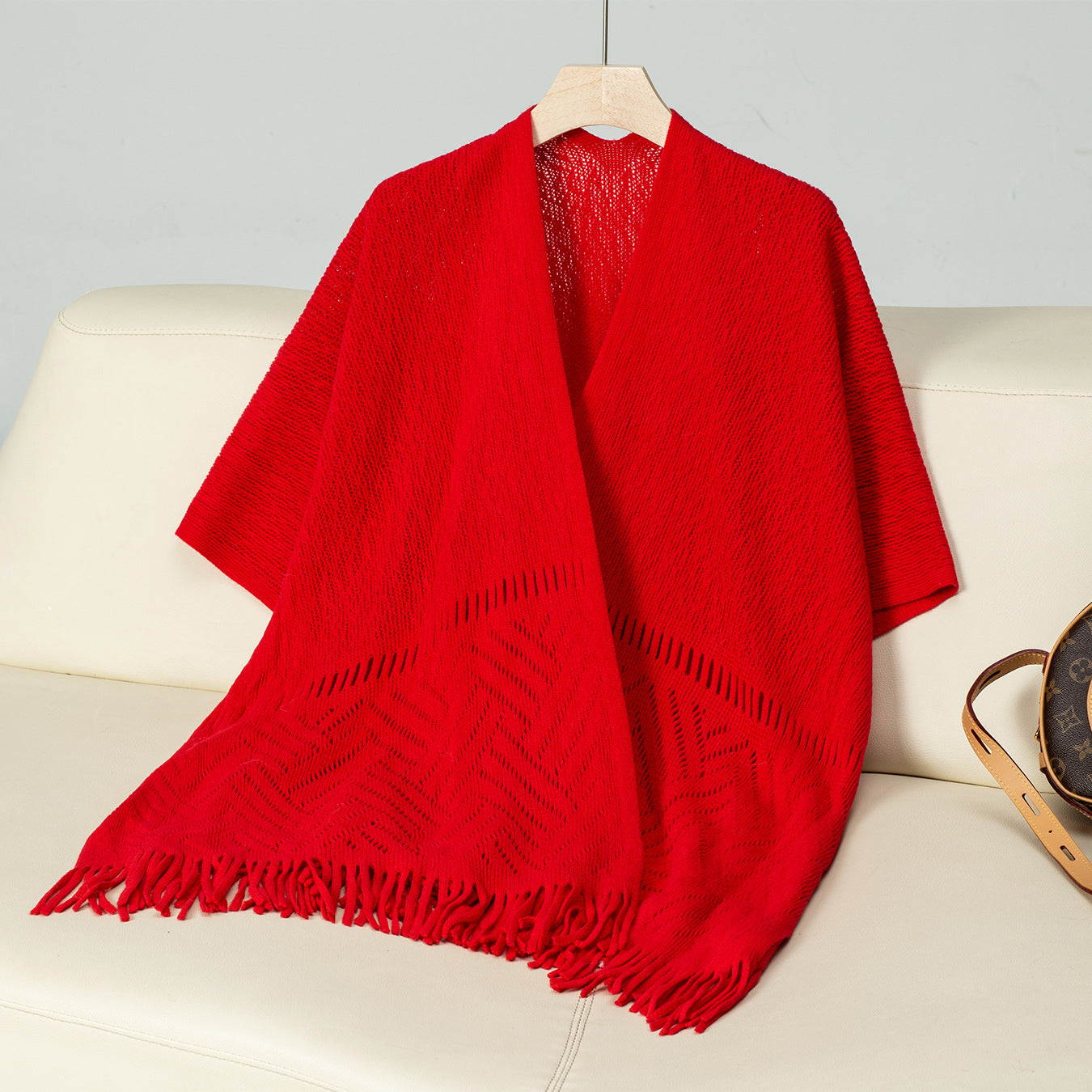 Ladies elegant knitted poncho with fringed details and striking pattern
