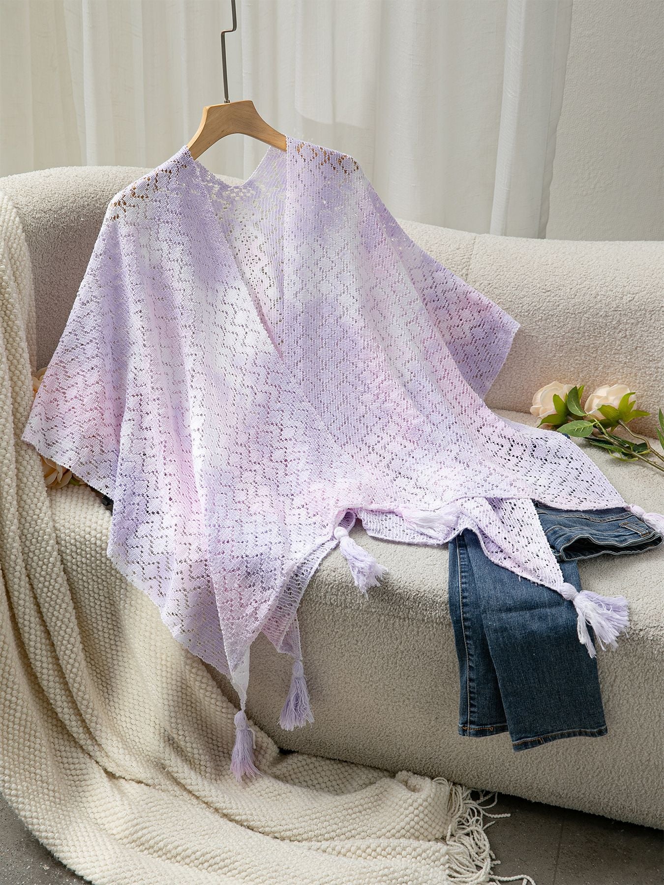 Ladies airy knitted poncho with decorative tassels